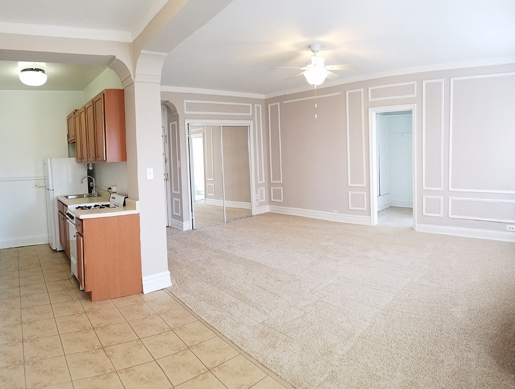 an empty kitchen and living room with a tile floor